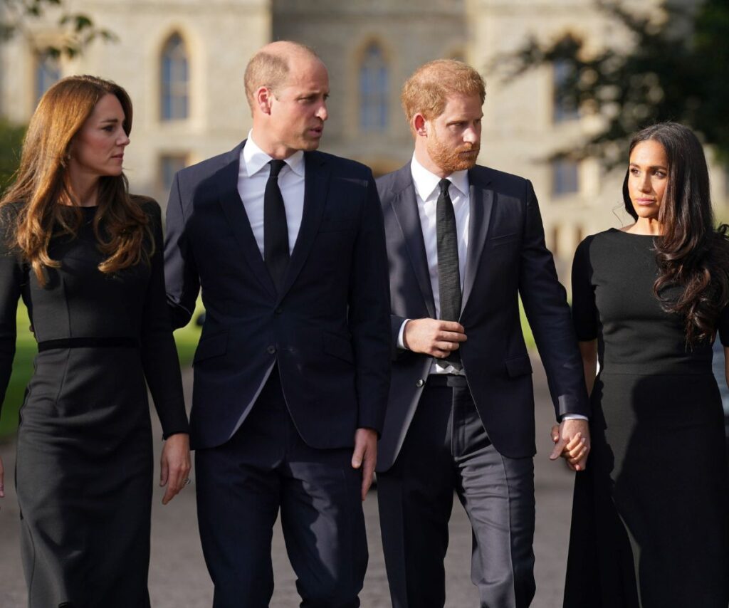 Kate Middleton, Prince William, Prince Harry and Meghan Markle walking together while all dressed in black.