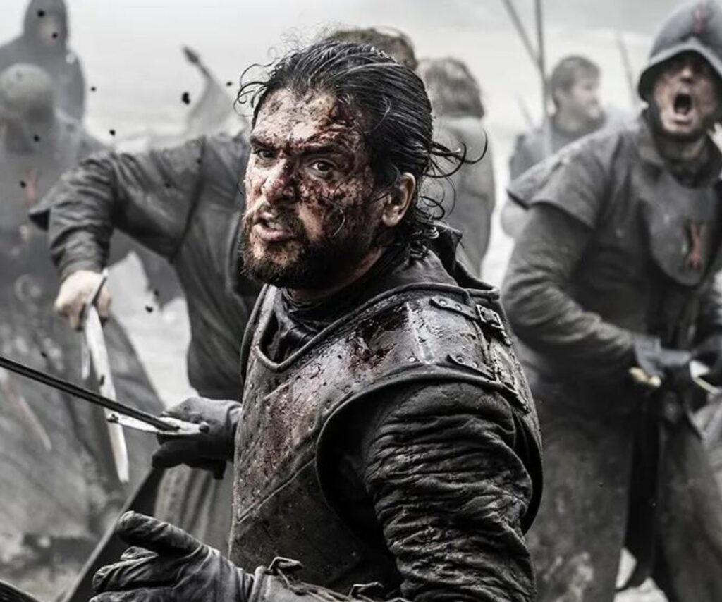Battle of the Bastards scene in Game of Thrones where actor Kit Harington stands face covered in blood, wearing armour and holding a sword with the rest of his army behind him