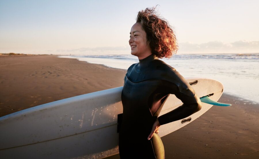 woman surfing in wetsuit in winter