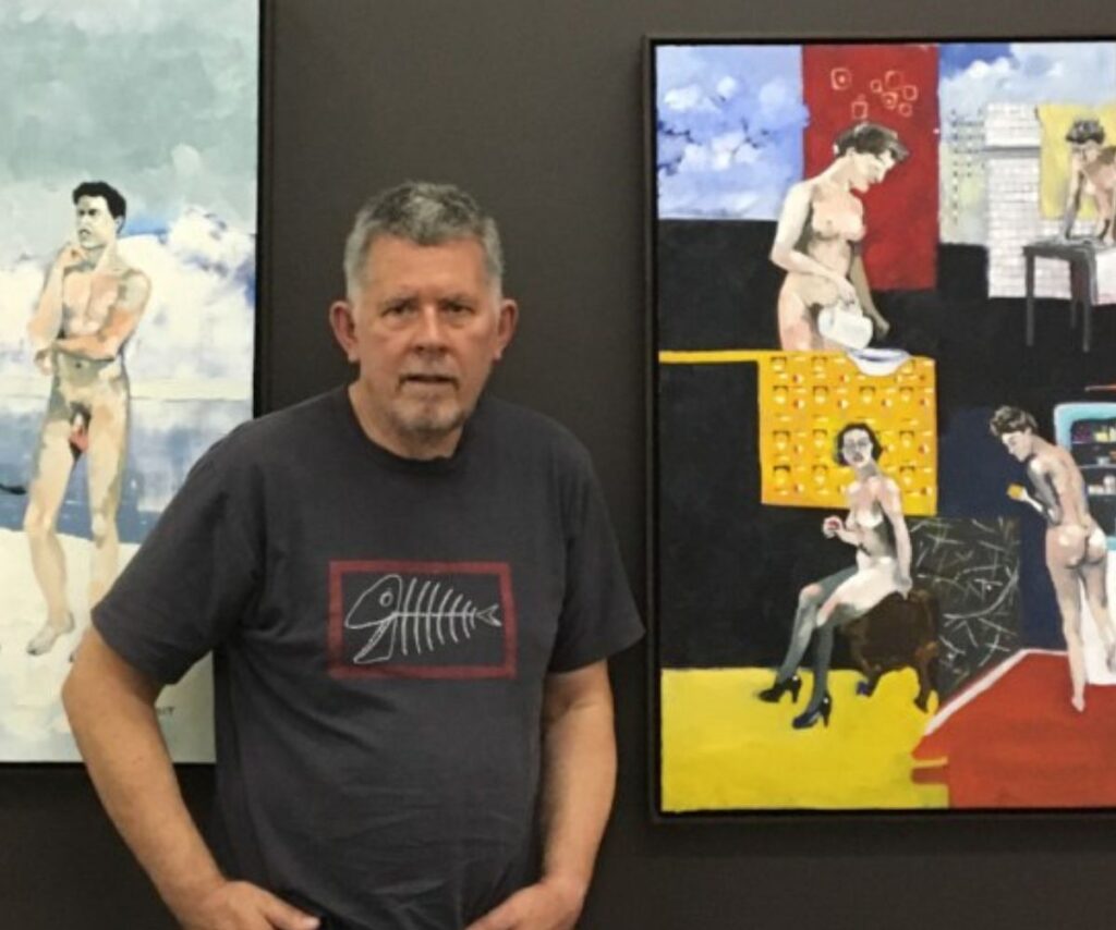 Harley stands proud wearing a t-shirt in front of his nude artworks