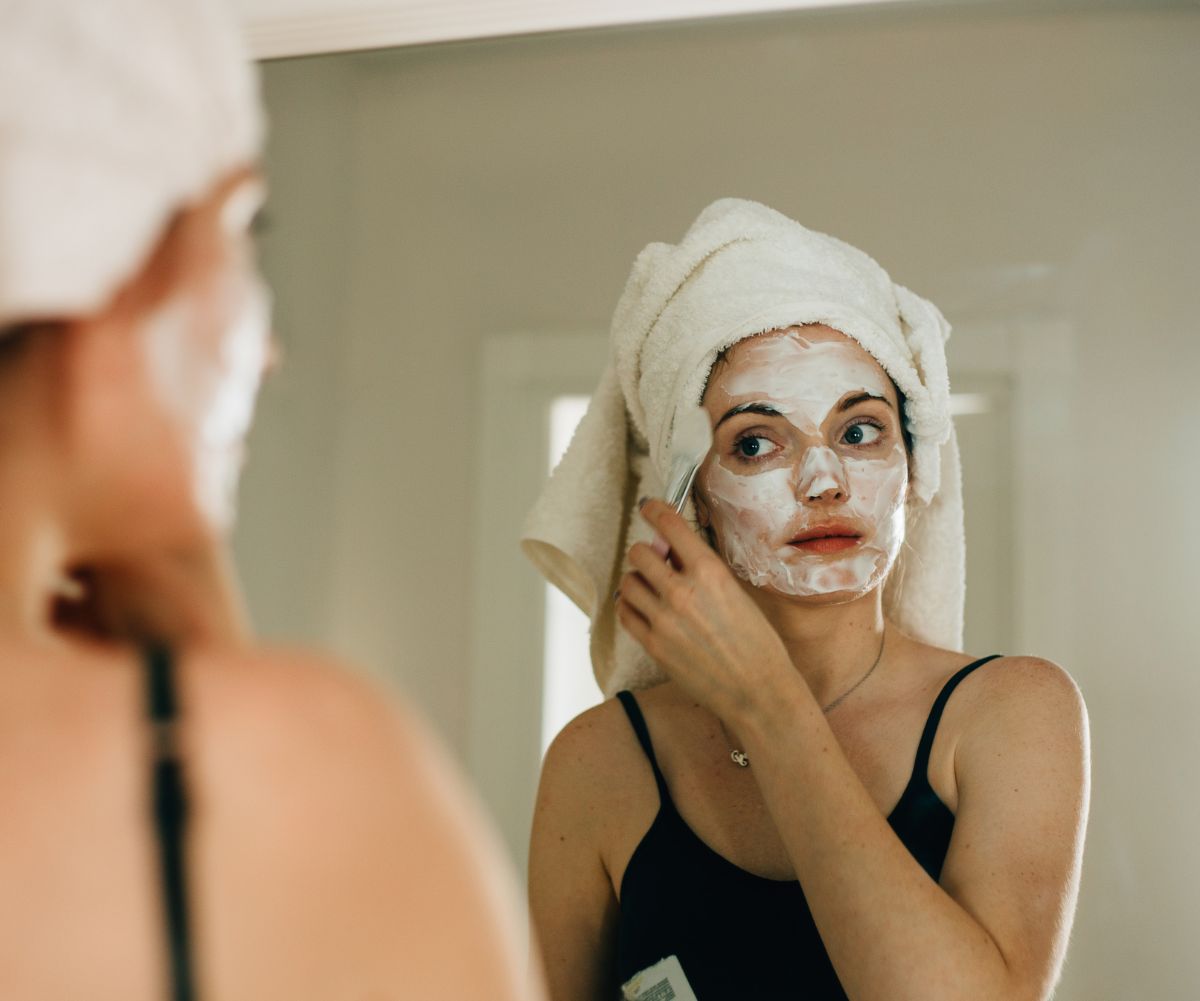 woman applying face mask in the mirror