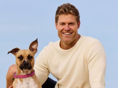 Dr Chris in white sweater with dog