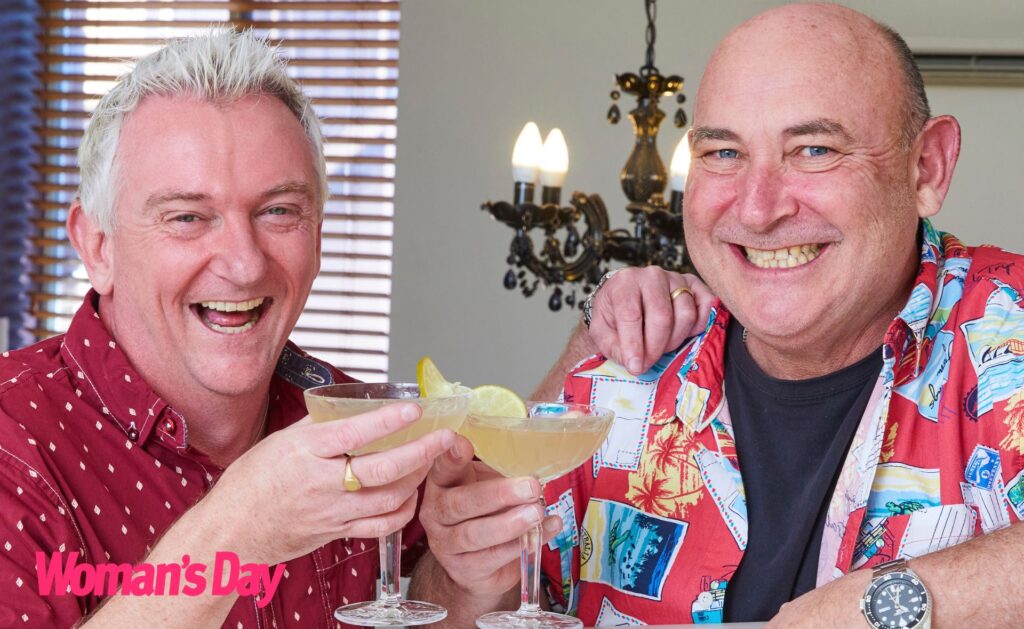 Travel Guides Matt and Brett 'cheersing' with their martinis and smiling wearing brightly coloured tops