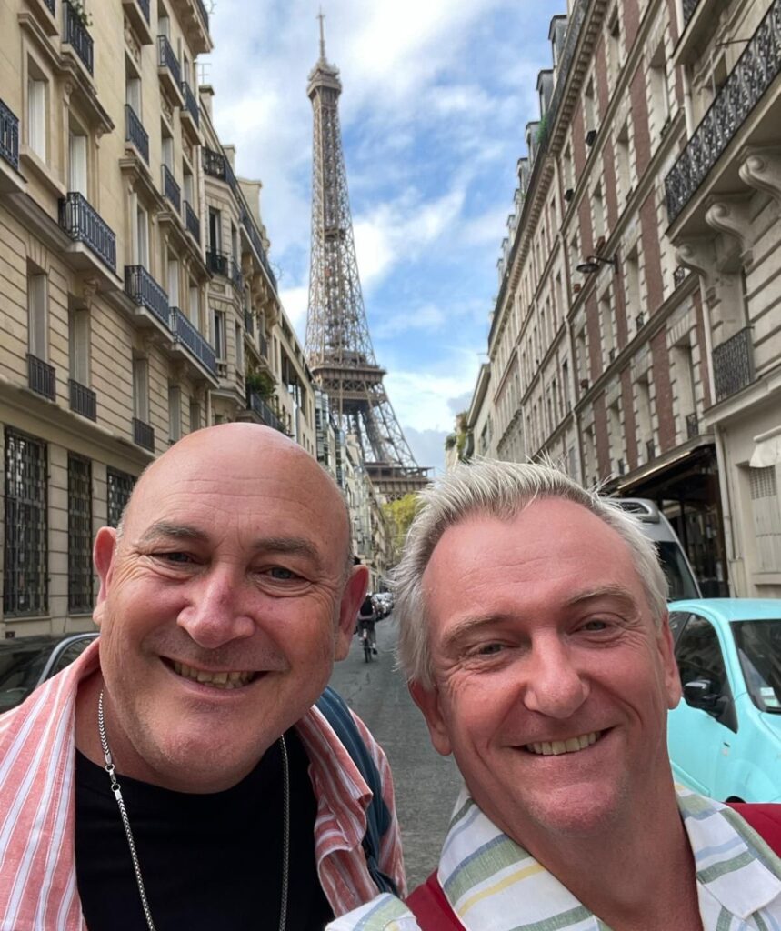 Travel Guides Matt and Brett in front of Eiffel Tower, smiling