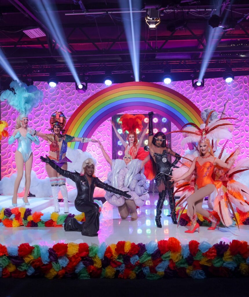 drag queens posing in front of a rainbow in competition for ru paul's drag race 