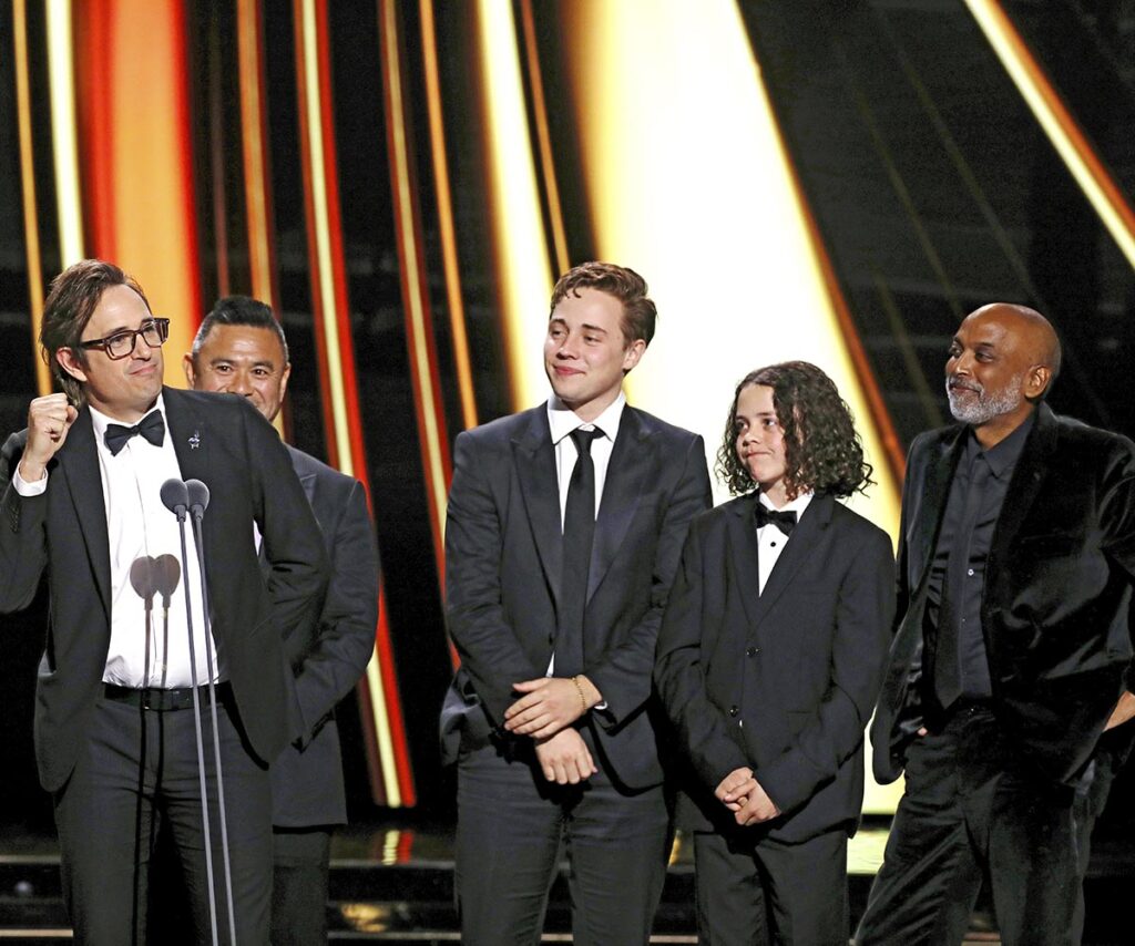 Trent Dalton, Lee Tiger Halley and Felix Cameron on stage accepting a Logie on behalf of Boy Swallows Universe