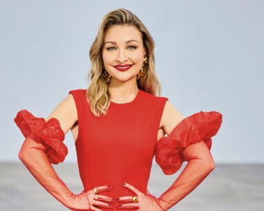 The Voice coach Kate Miller Heidke smiles in a red dress with hands on hips