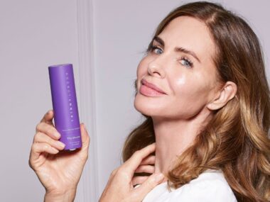 Trinny holding a bottle of Elevator skincare