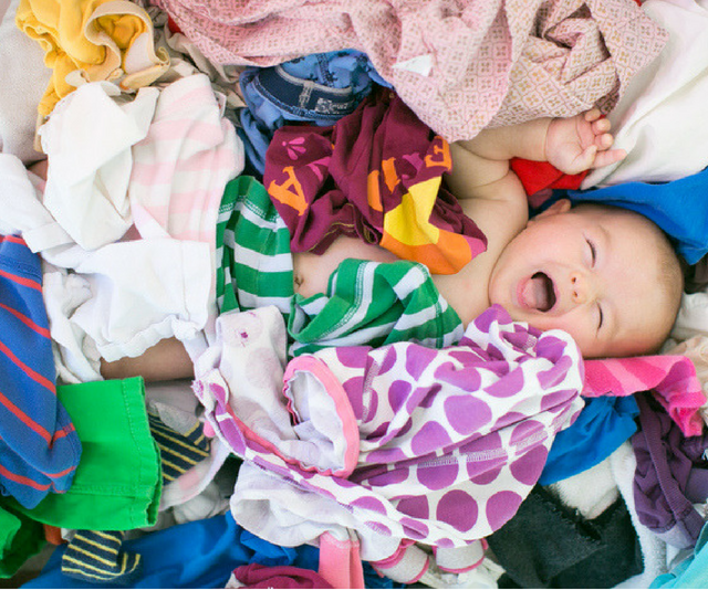 Laughing baby in pile of laundry