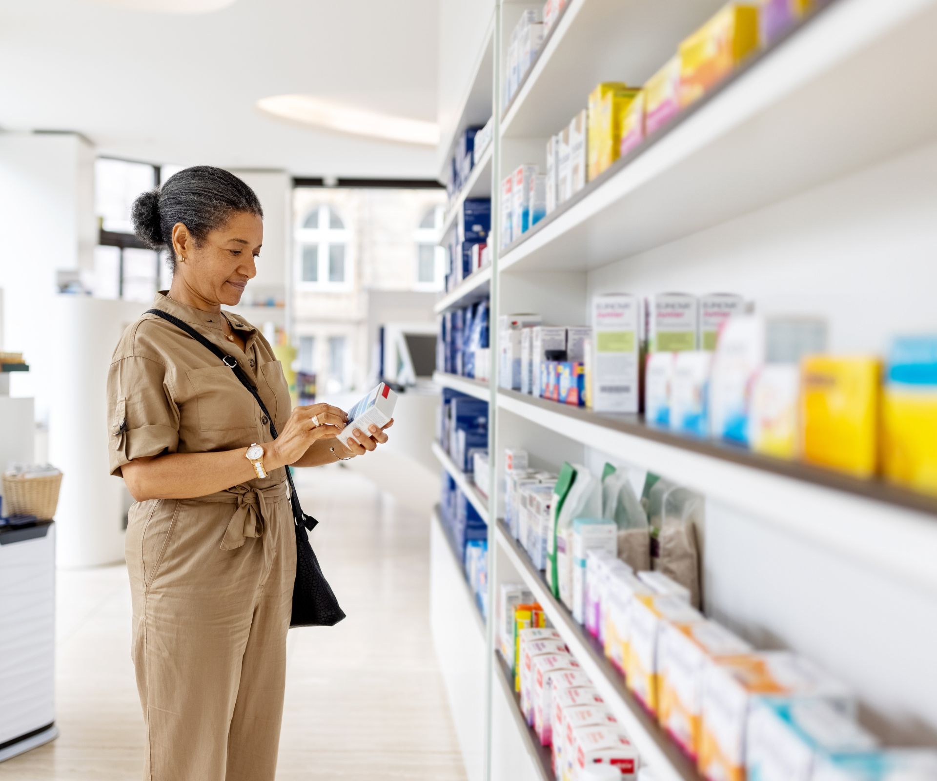 Woman choosing medicine in pharmacy